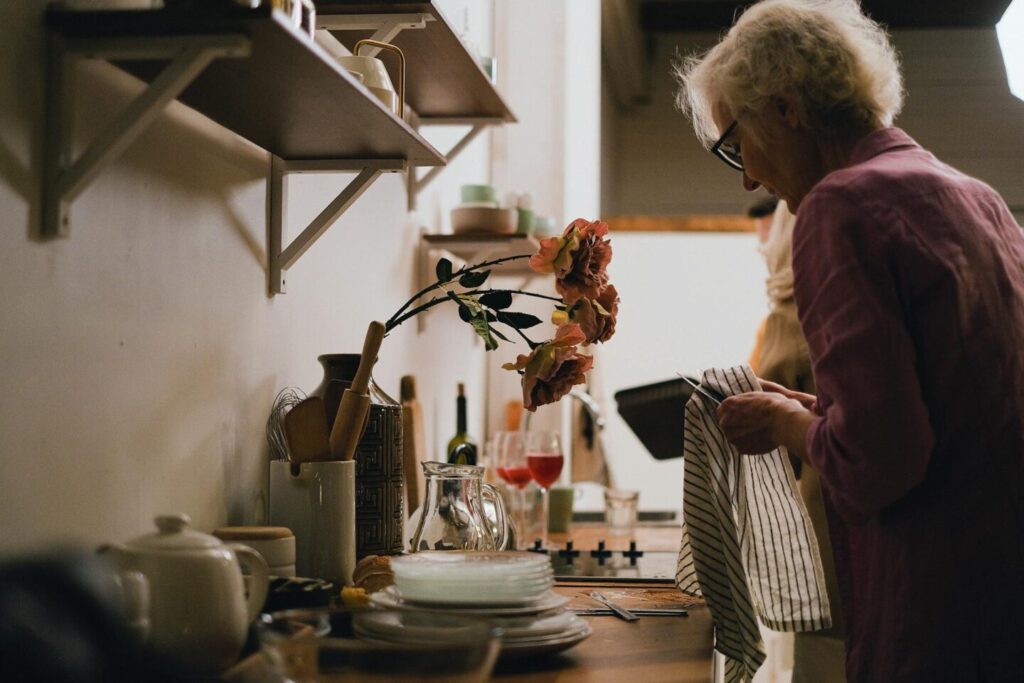 A woman is washing dishes at the sink.